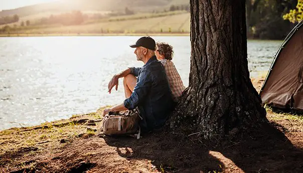 senior-couple-camping-by-a-lake-P8KD3W4